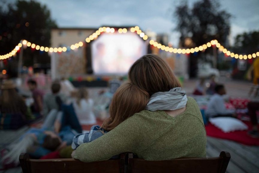 Affectionate mother and daughter at movie in the park