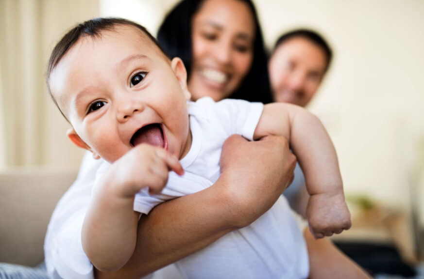 Affectionate young couple in love with a baby at home