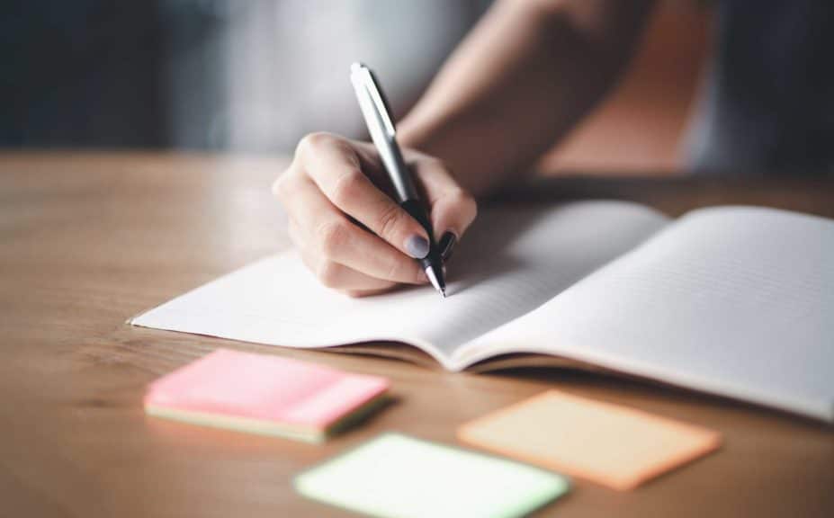 Business woman holding pens and papers making notes