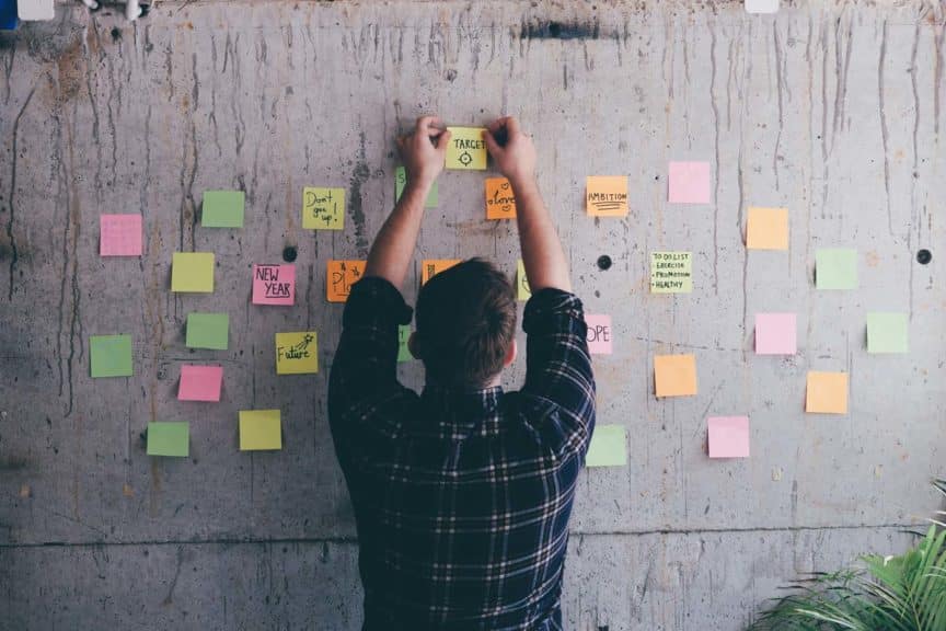 Businessman writing inspirational notes on sticky notes