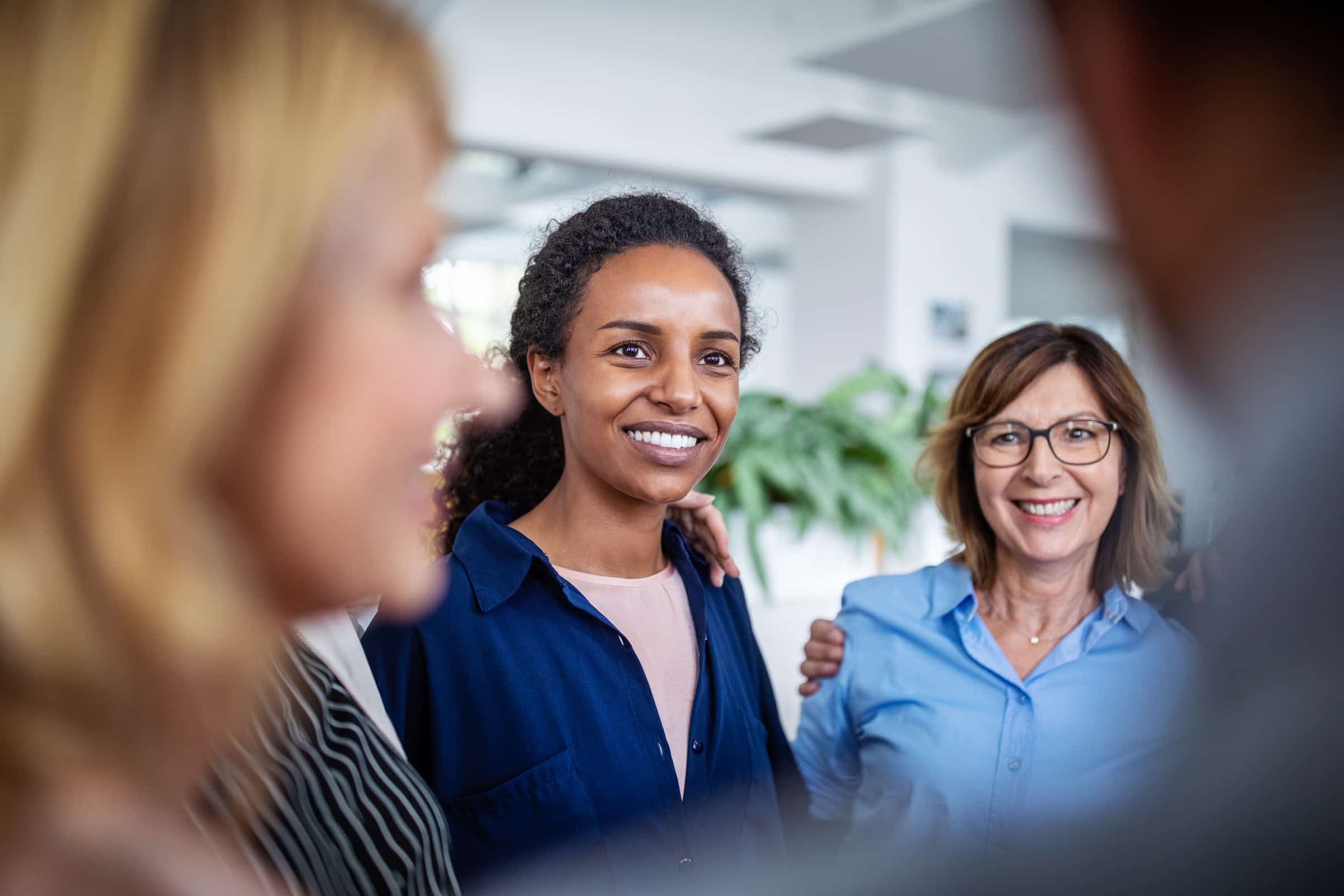 Businesswoman huddling with coworkers in office