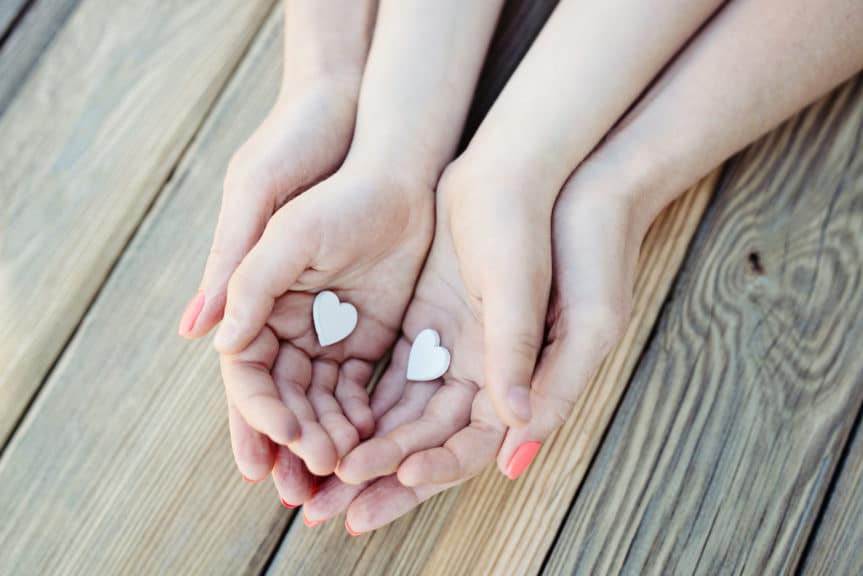 Child and mother holding hearts in their hands