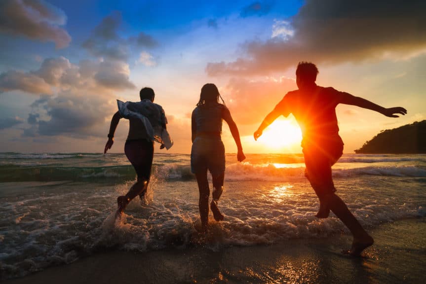 Family playing on beach sunset