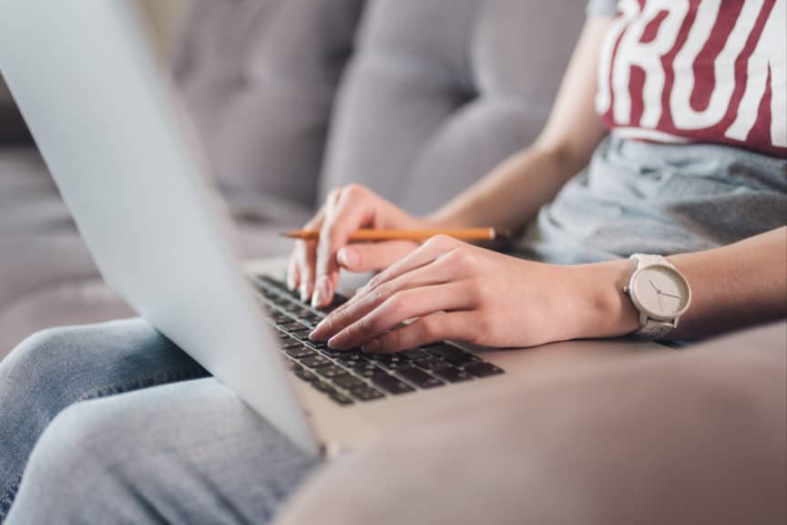 Female hands typing on laptop at home