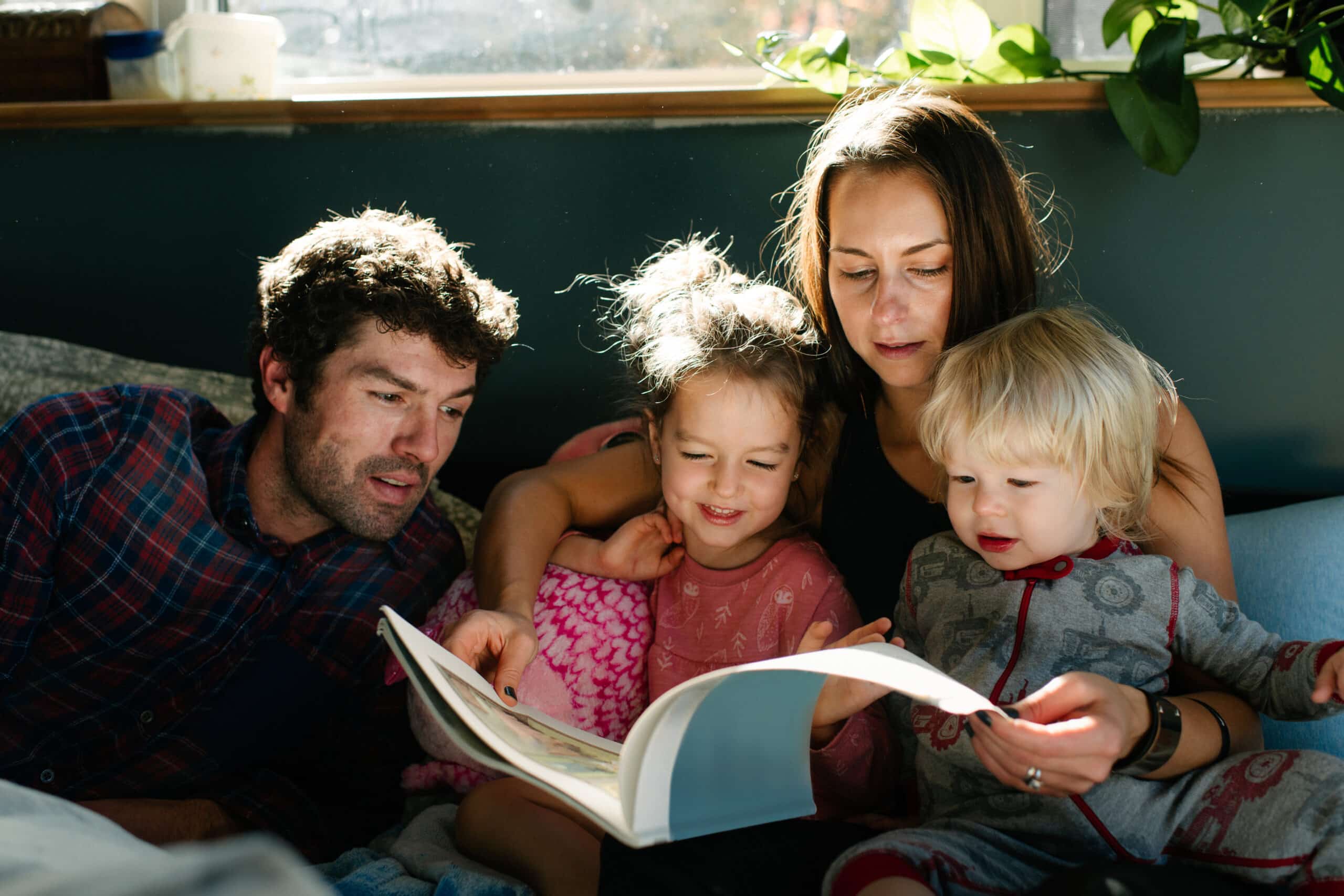 Parents reading to children in bed