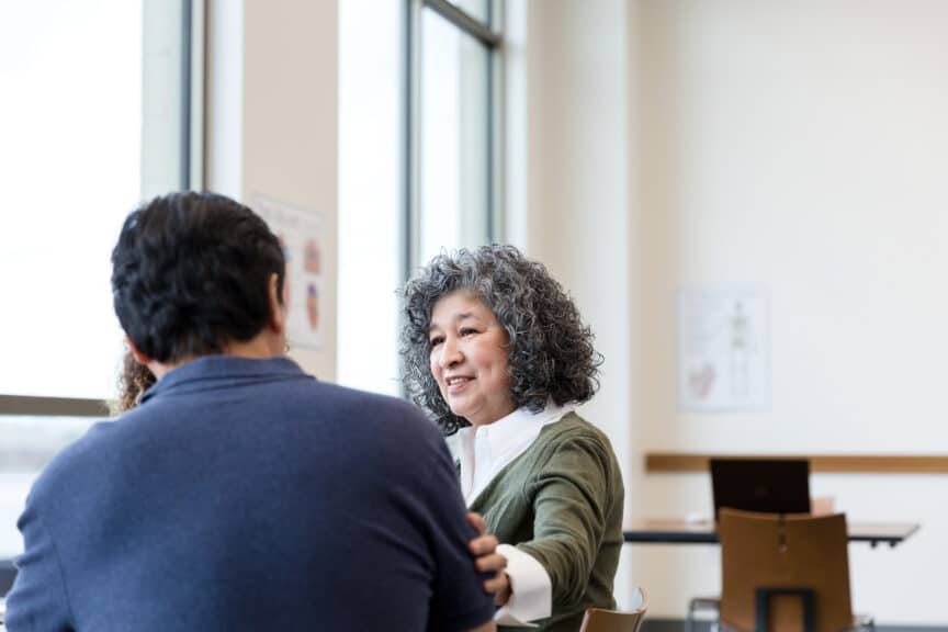 woman putting her hand on arm of man in comforting way