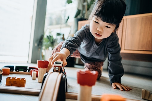 young asian girl playing trains