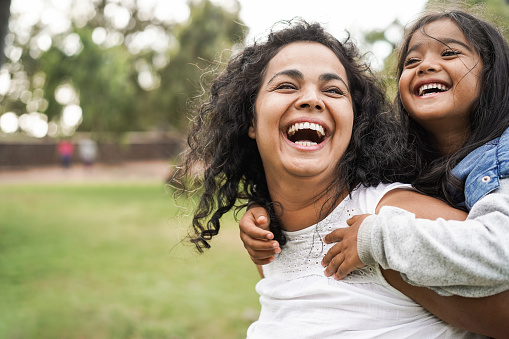 Happy mom giving piggyback ride to daughter