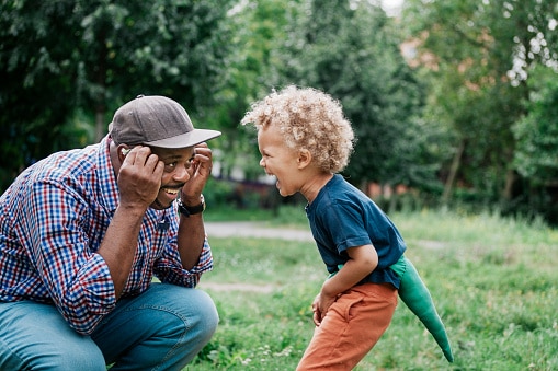 young boy laughing at father