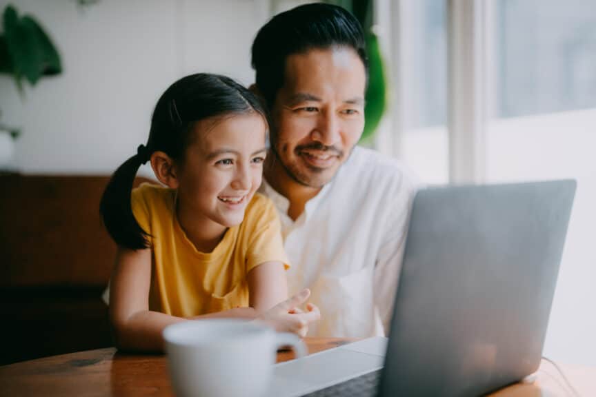 Father and young daughter on laptop