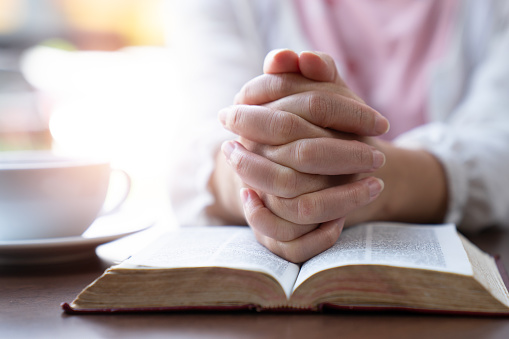 prayer hands over bible