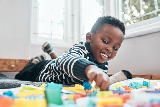 young african american boy playing with toys on the floor