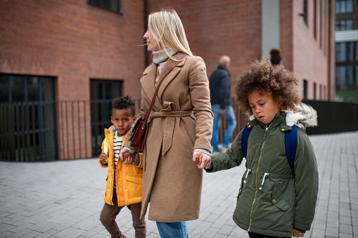mother walking two children to school
