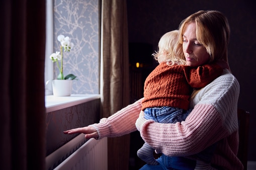 mother holding son near window