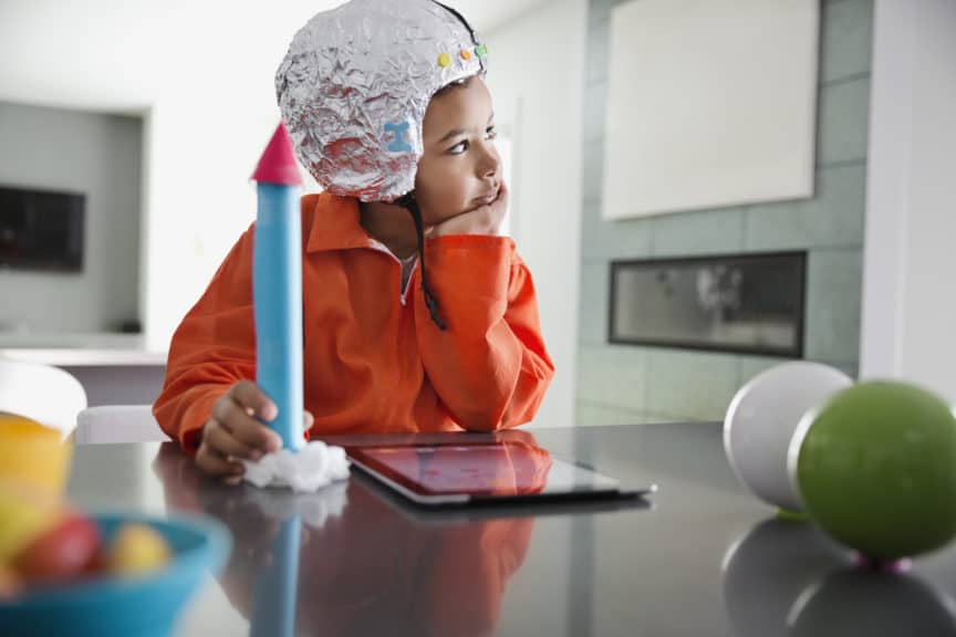 Thoughtful boy pretending to be astronaut at home