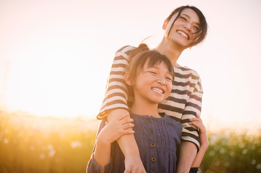 Mother and daughter smiling in a field