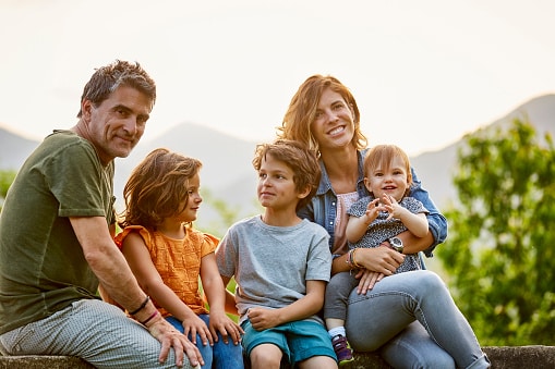 Family smiling and sitting outside