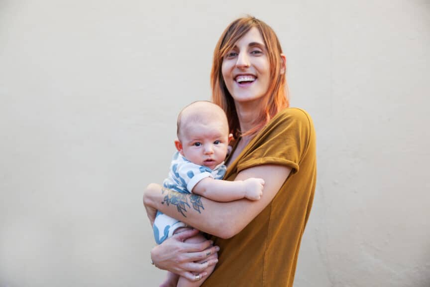 mother smiling and holding her baby