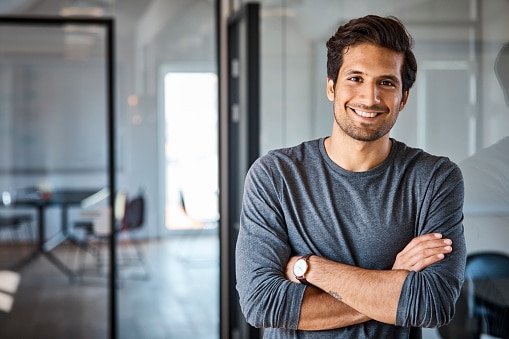 Man with arms crossed while smiling