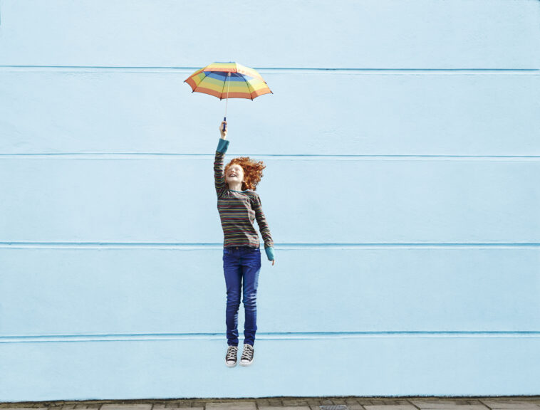 Girl jumping with umbrella