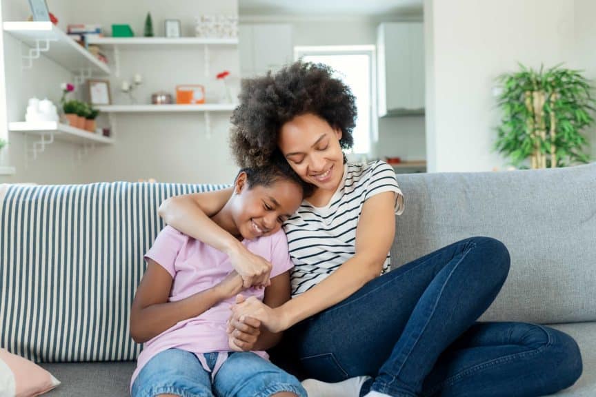 Happy Mom and Small Preschooler Girl Child Embrace Cuddle 