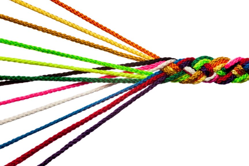 Individual strands of colored rope braided into a single cord - like individuals uniting  to become a team