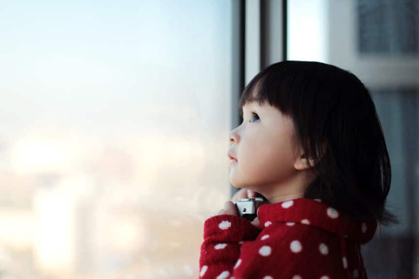 Little girl looking out of window