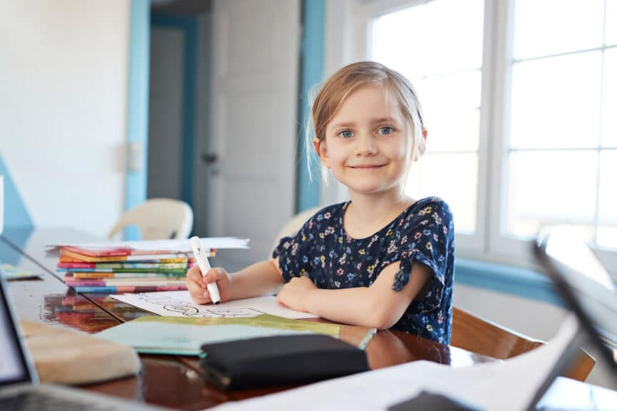 Portrait confident girl doing homework at dining table