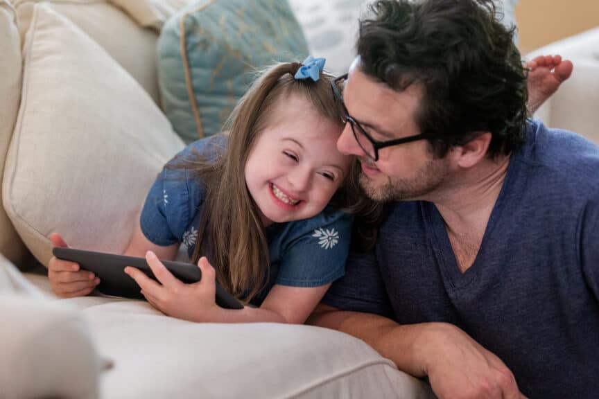 Young-girl-with-Down-Syndrome-giggles-with-dad