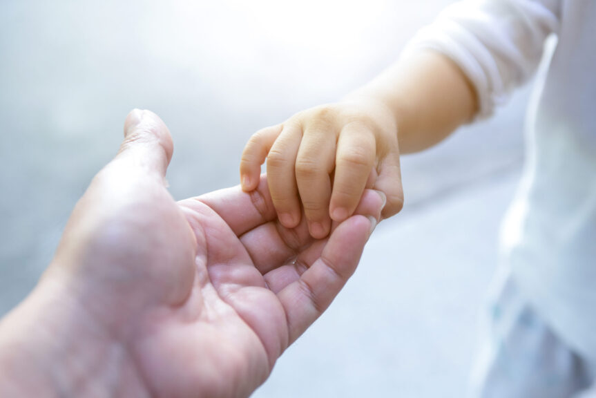 adult reaching for child's hand
