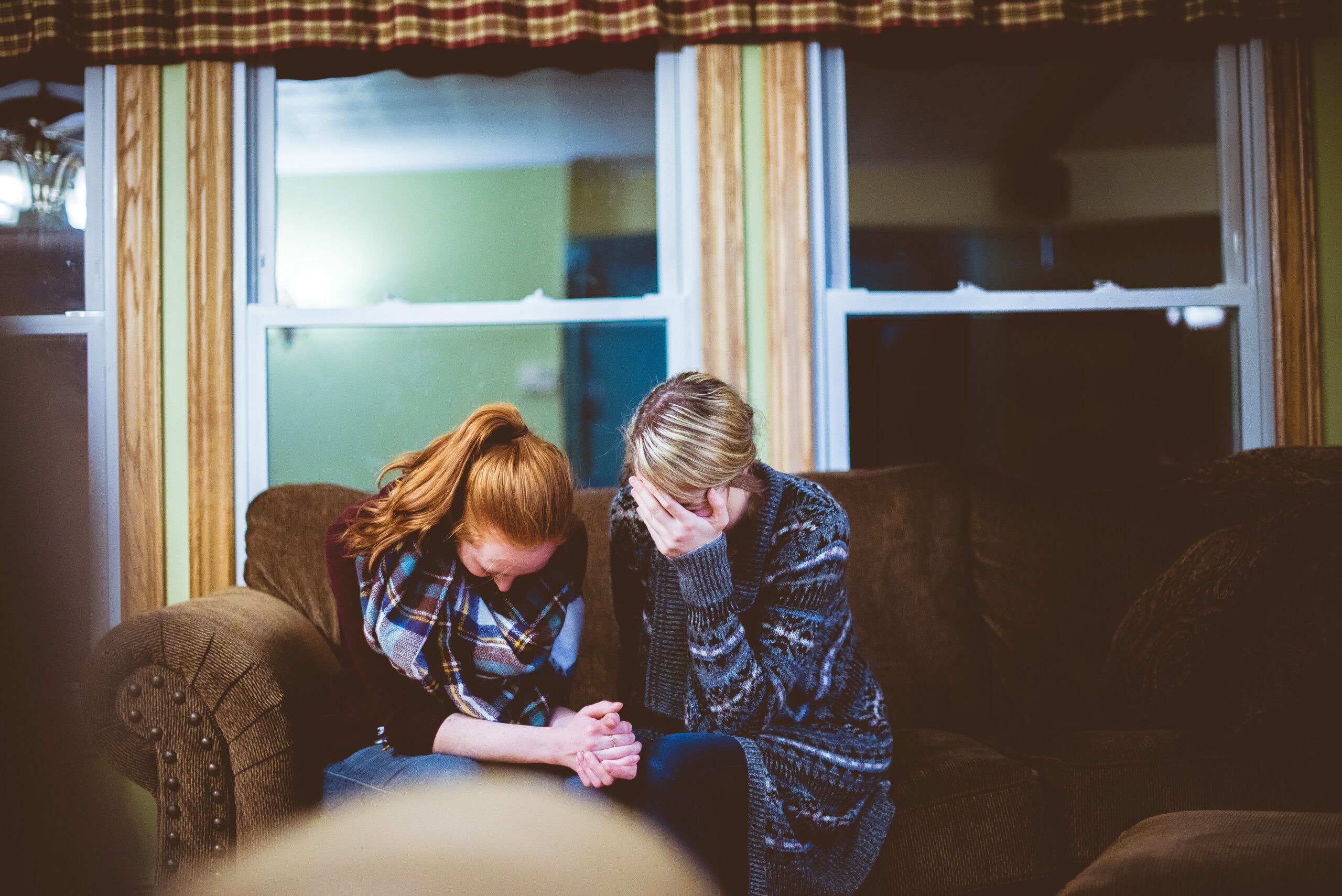 woman reading and praying on couch