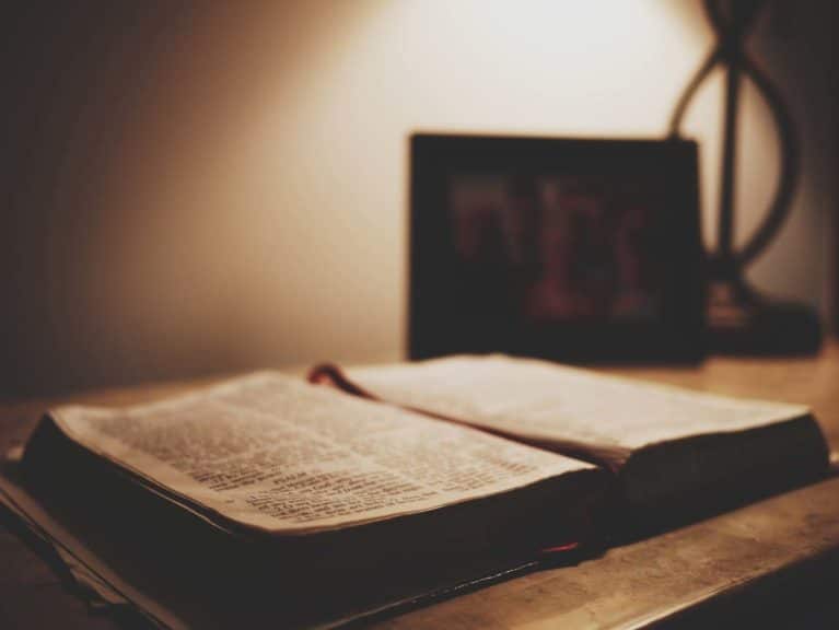 Bible open on nightstand in dark lighting