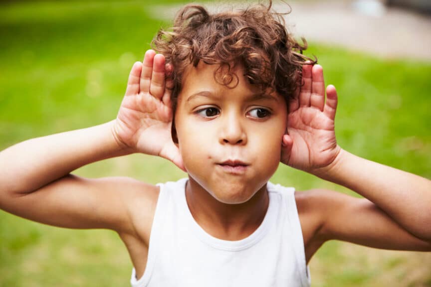 boy making faces and listening with ears