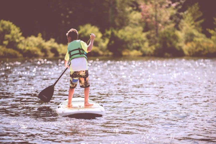 boy on a paddle board at the lake