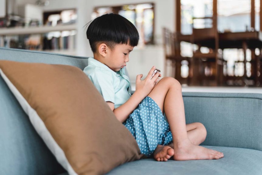 boy-using-smart-phone-living-room