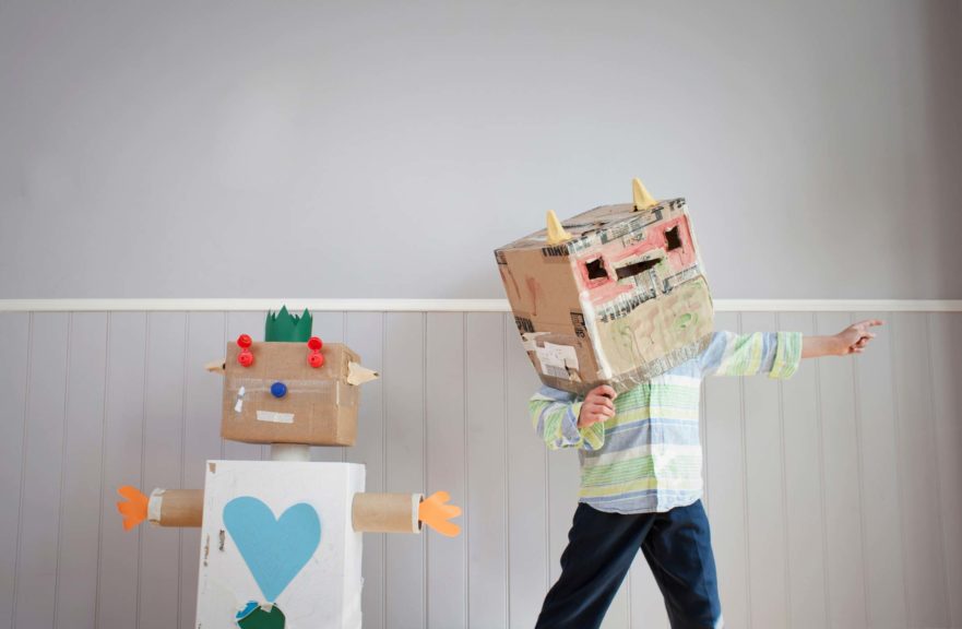 Boy with box covering head and homemade toy robot