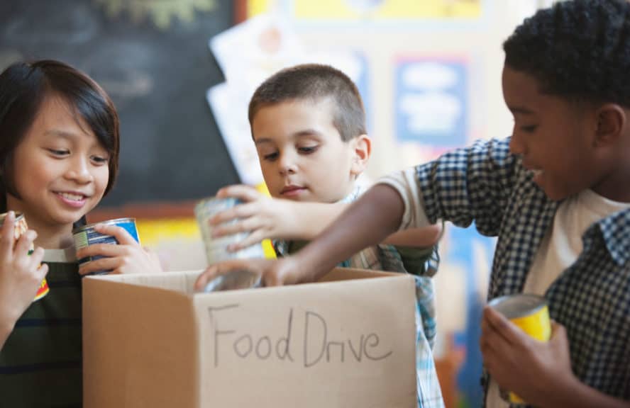 Boys packing box with food for school food drive