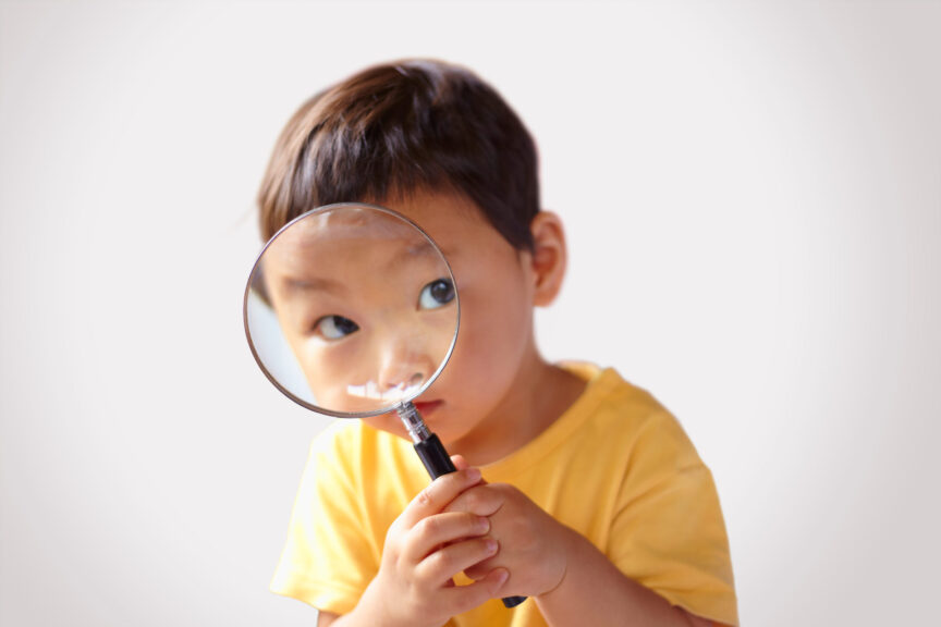 toddler looking through a magnifying glass