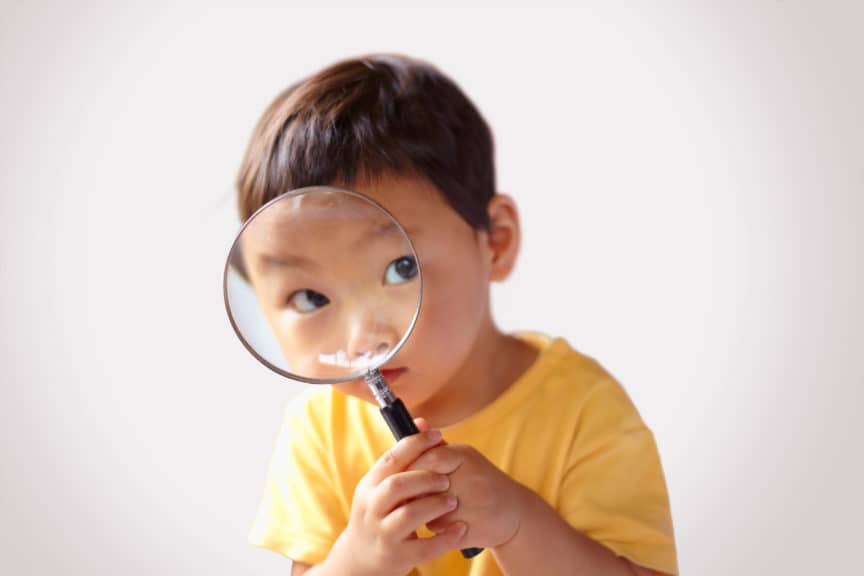 Child looking into a magnifying glass