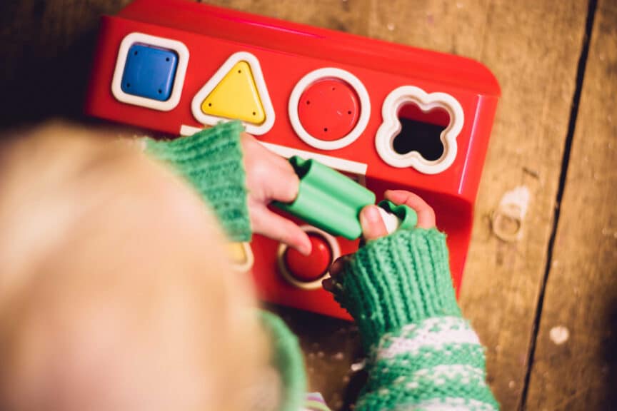 child playing with shape board