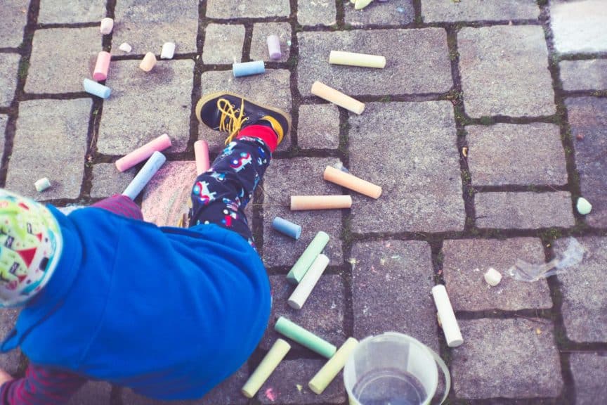 child-playing-with-sidewalk-chalk-outside