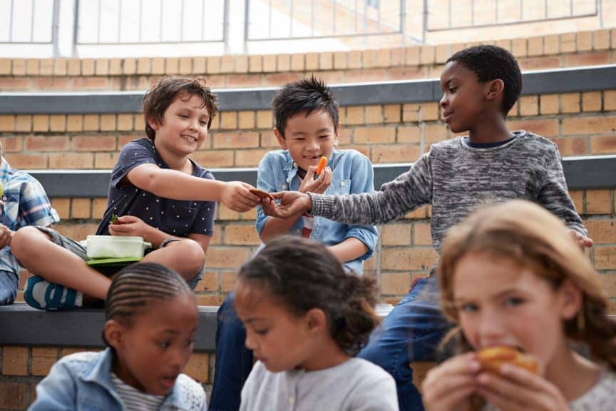 School children having lunch together outside the building