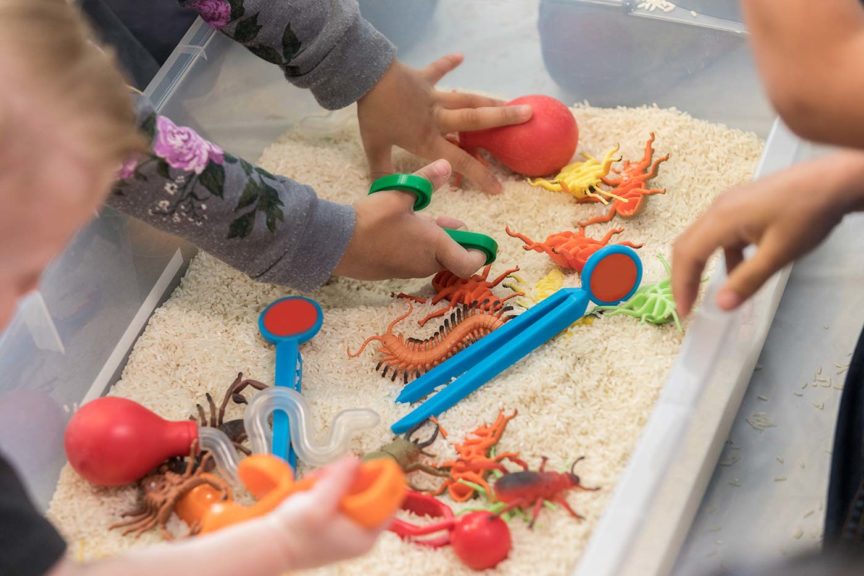 children play sensory toys bin