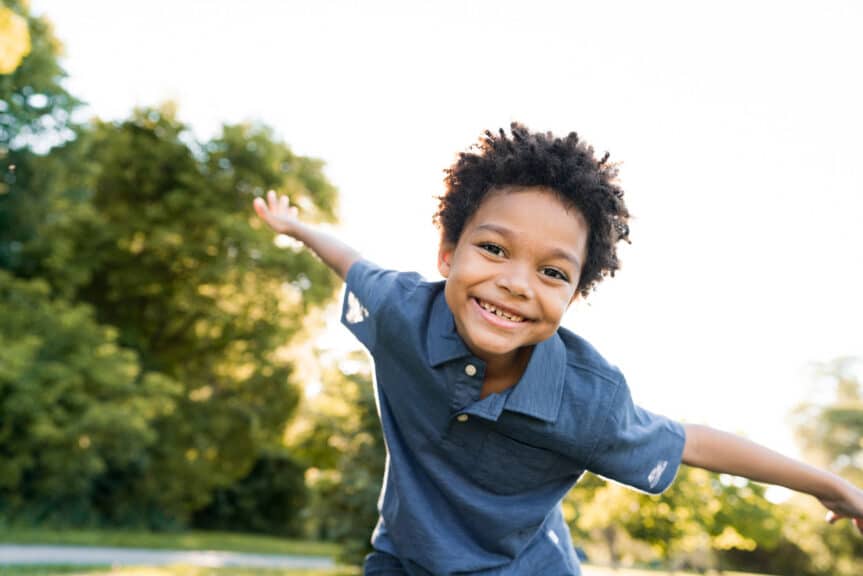 A young boy smiles while spending time outside at church.