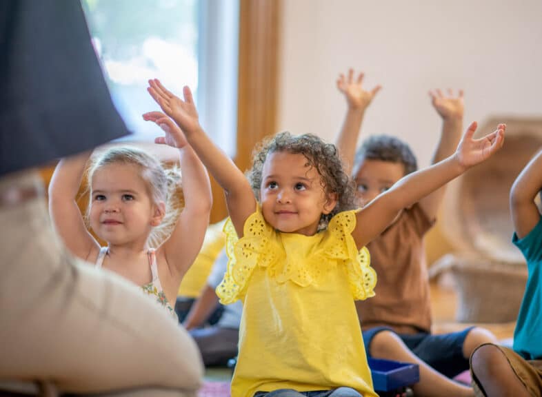 A group of young kids sing during a children's ministry worship time.