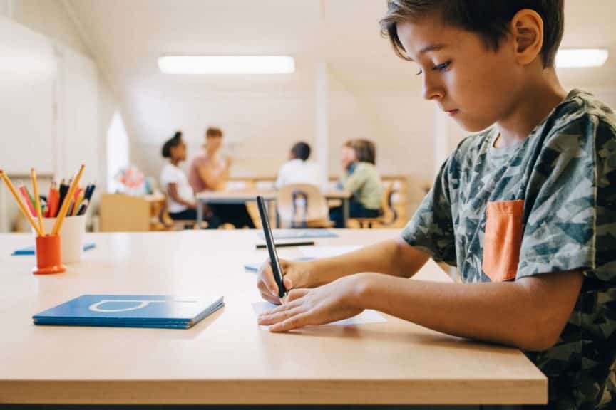 closeup-boy-concentrating-writing-table