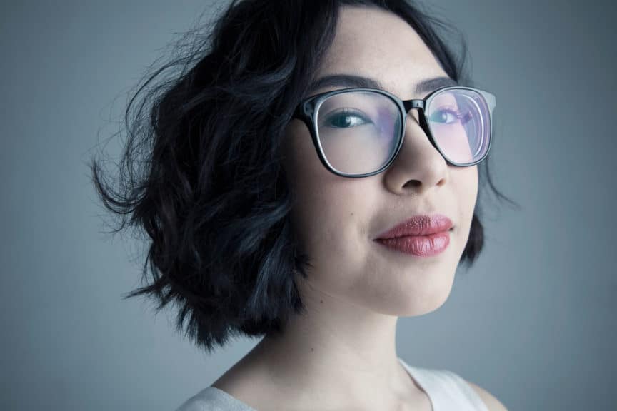 Close up portrait confident young woman with black hair and eyeglasses