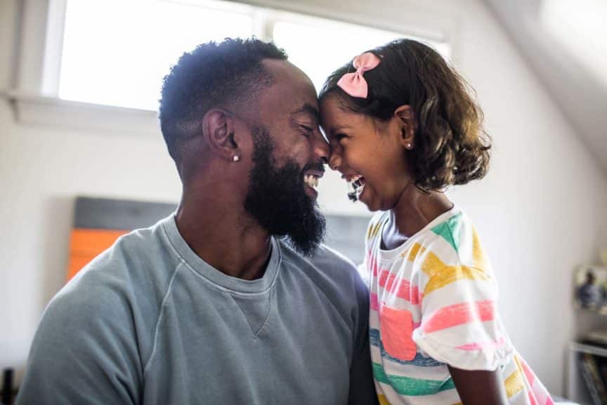 father and daughter laughing in bedroom