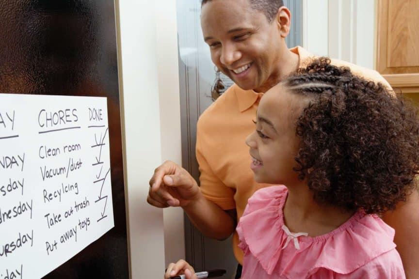 father and daughter looking at the chores chart
