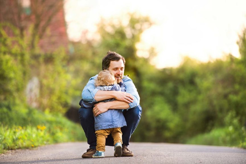 father hugging little boy